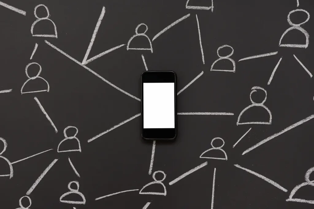 Fond de tableau noir avec un téléphone au centre. Autour du téléphone, des traits dessinés à la craie représentent les connexions entre les personnes.